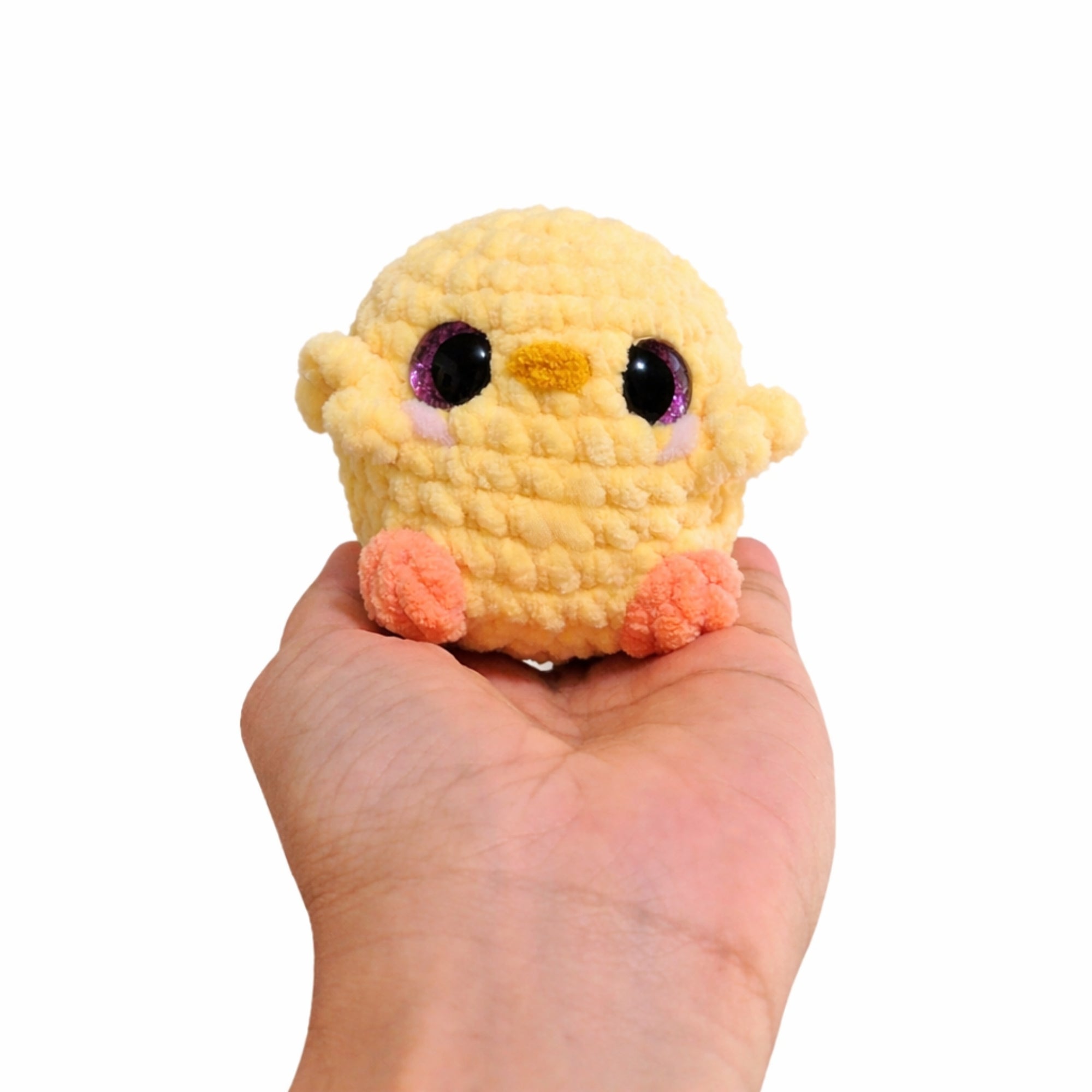 small crochet baby chick plush held in hand showing size