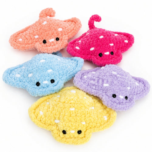 Colorful crochet baby stingray plush toys in multiple colors including pink, blue, yellow, and purple, handmade amigurumi ocean animals displayed together