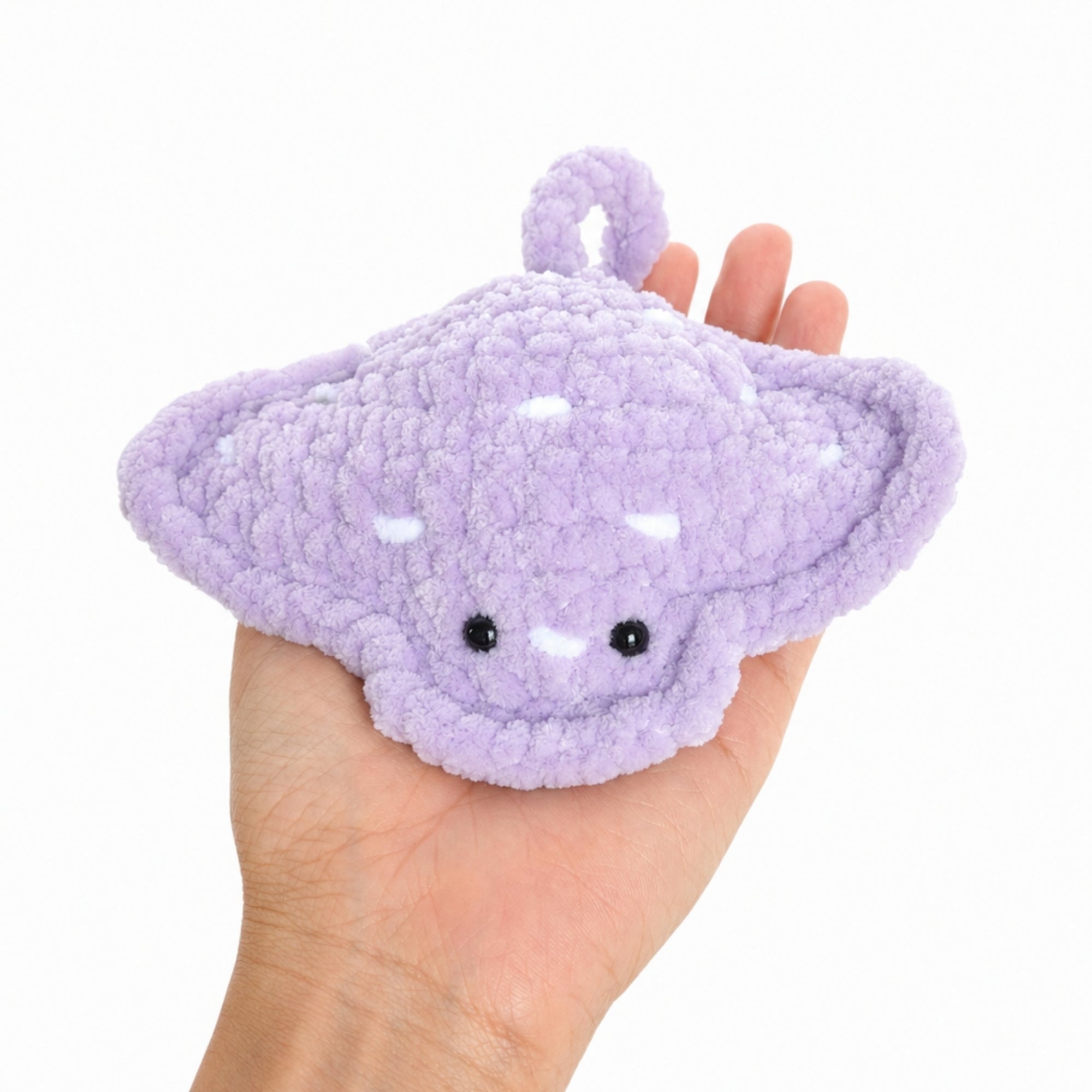Crochet baby stingray plush shown resting in a hand to display real size, soft handmade amigurumi ocean toy with cute face and plush texture