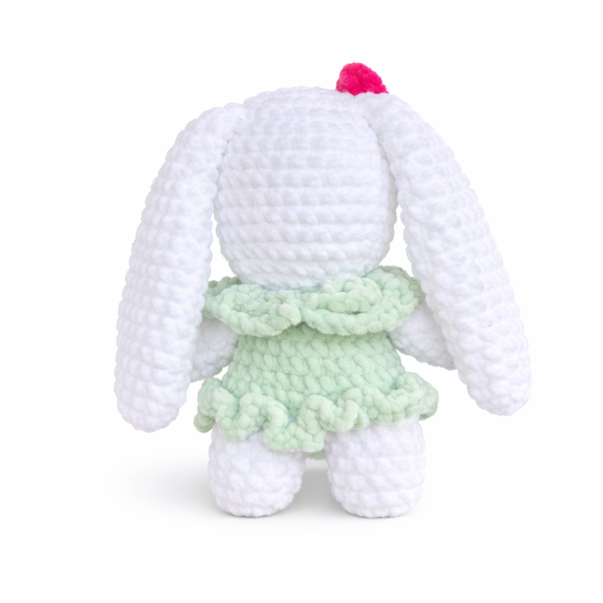 Back view of handmade crochet bunny plush wearing a green dress.