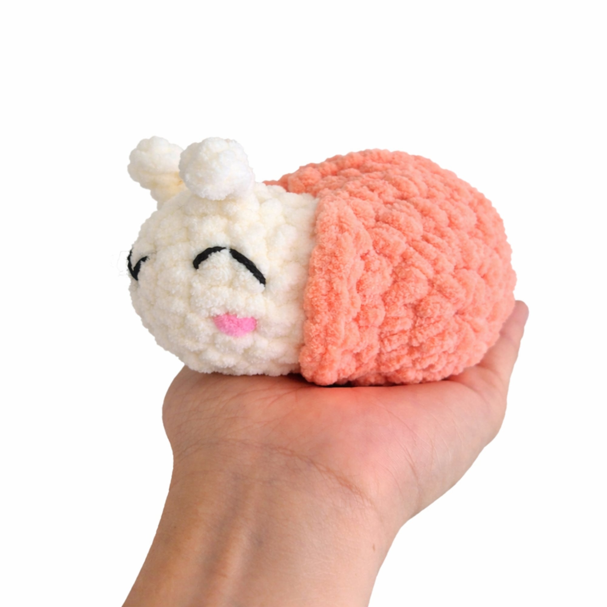 Handmade crochet snail amigurumi plush showing size in hand.