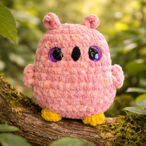 handmade crochet owl amigurumi plush toy on tree branch in forest